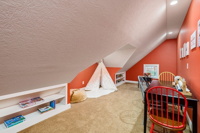 playroom featuring a textured ceiling, carpet floors, and vaulted ceiling