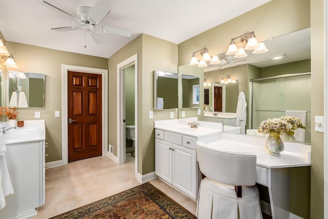 bathroom with ceiling fan, vanity, an enclosed shower, and toilet