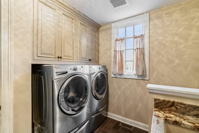 washroom featuring a textured ceiling, washer and clothes dryer, cabinets, and dark hardwood / wood-style floors