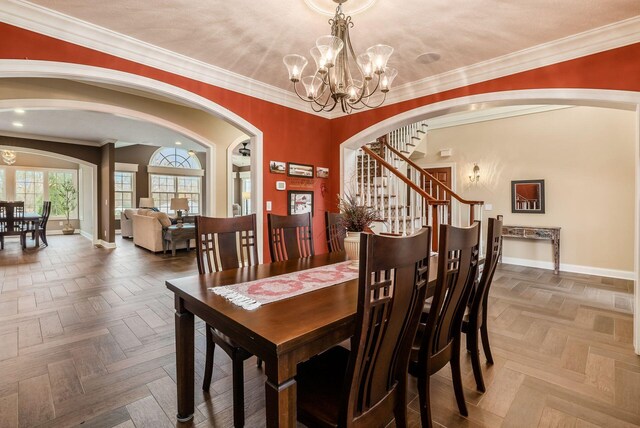 dining room with parquet flooring, ornamental molding, and an inviting chandelier