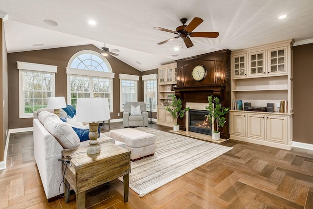 living room featuring parquet flooring, a large fireplace, ceiling fan, and lofted ceiling