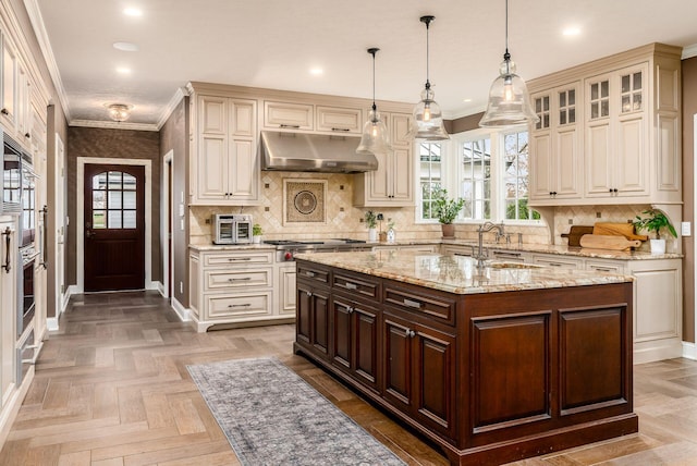 10492 Allen Rd, Pickerington, OH 43147 - kitchen featuring under cabinet range hood, ornamental molding, plenty of natural light, cream cabinetry, and recessed lighting