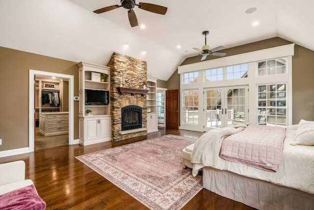 bedroom with a stone fireplace, dark hardwood / wood-style flooring, lofted ceiling, and french doors