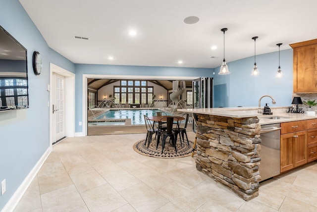 kitchen featuring stainless steel dishwasher, pendant lighting, light tile patterned floors, and sink