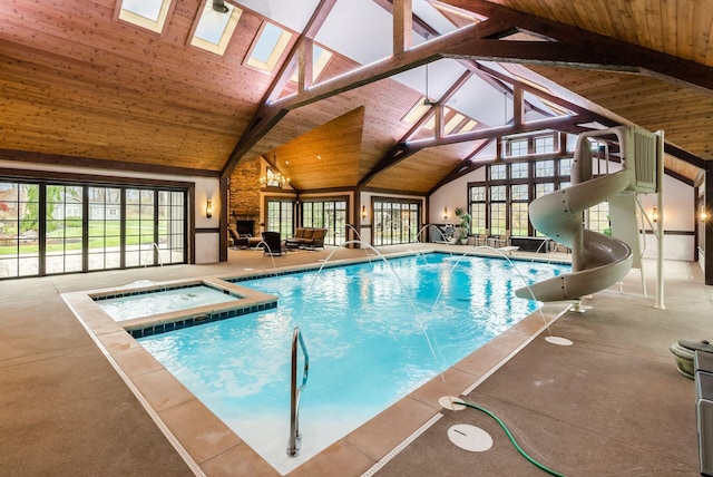 view of swimming pool featuring an indoor hot tub, a patio, and a water slide