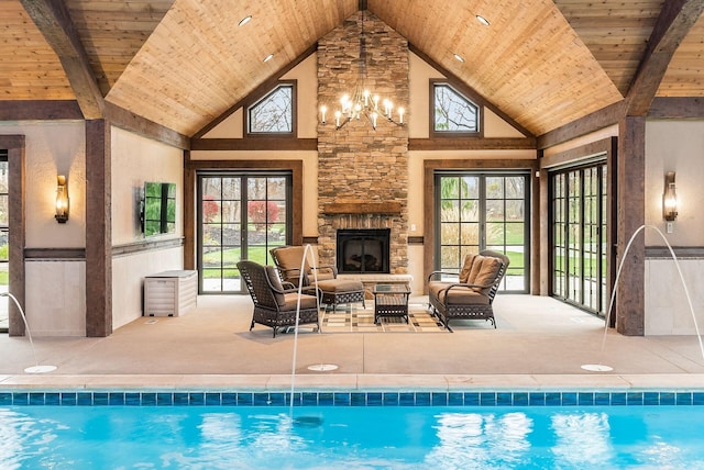 view of pool featuring a fireplace and a notable chandelier