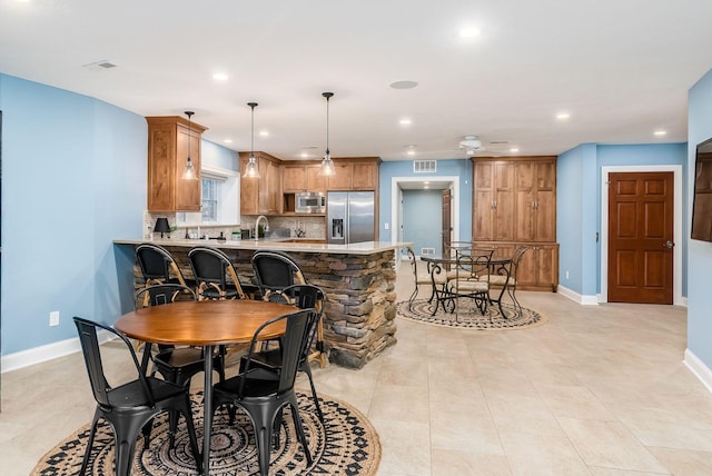 dining area with ceiling fan and light tile patterned flooring