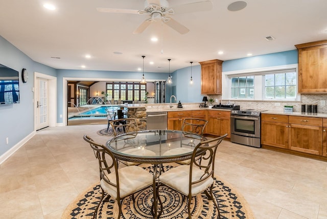 kitchen featuring ceiling fan, sink, stainless steel appliances, backsplash, and pendant lighting