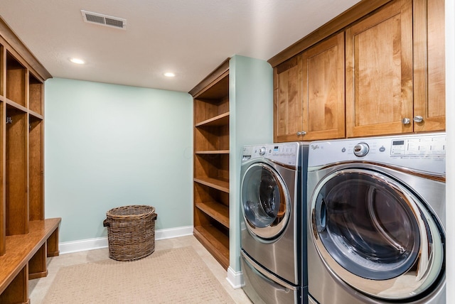 laundry area with cabinets, light tile patterned floors, and washing machine and dryer