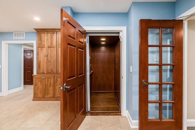 hall with elevator and light tile patterned flooring