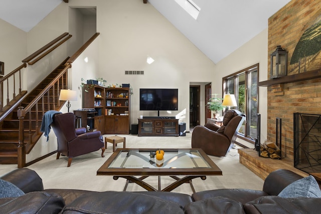 carpeted living room with a fireplace, high vaulted ceiling, and a skylight