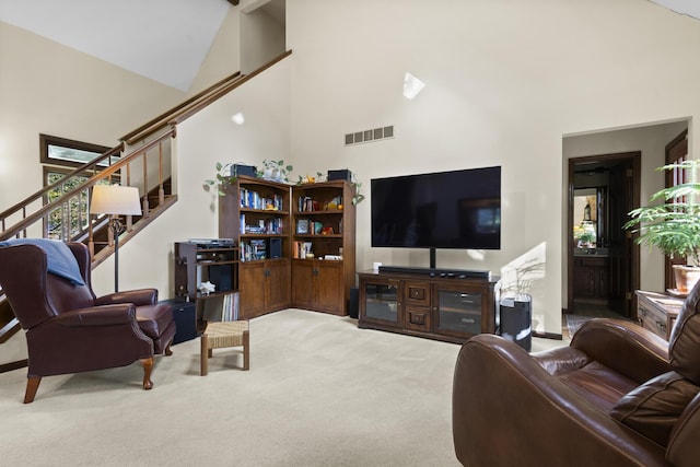 carpeted living room featuring high vaulted ceiling