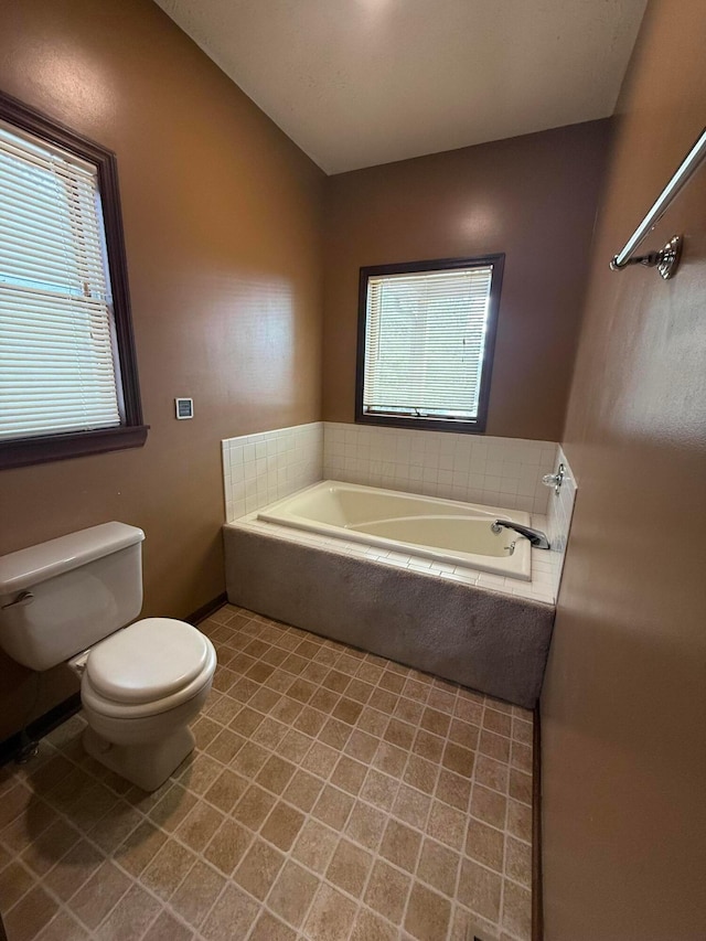 bathroom featuring toilet, a garden tub, and plenty of natural light