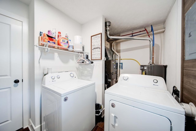 laundry area with gas water heater and washing machine and clothes dryer