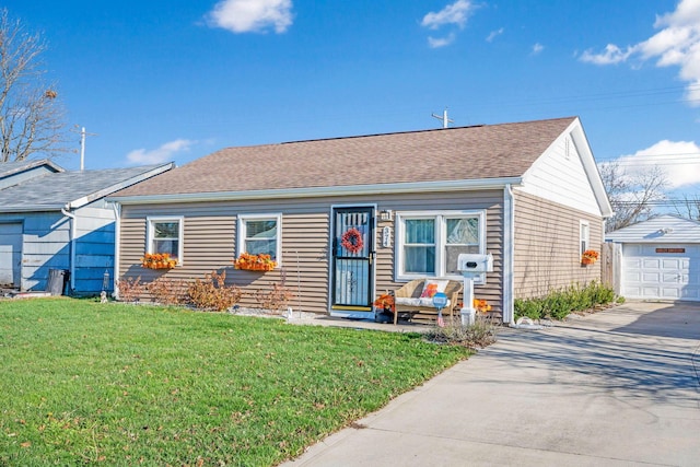 view of front of house featuring a front yard, an outbuilding, and a garage