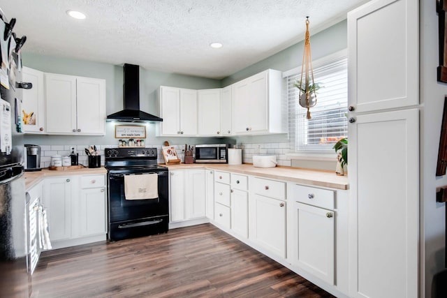 kitchen featuring white cabinets, wall chimney range hood, a textured ceiling, and black electric range