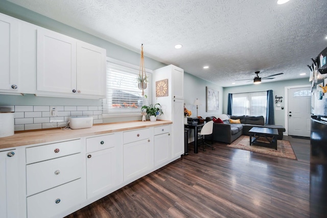 kitchen featuring white cabinets, wood counters, ceiling fan, and a textured ceiling