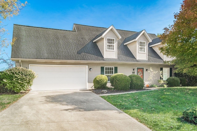 new england style home with a garage, concrete driveway, a shingled roof, and a front lawn