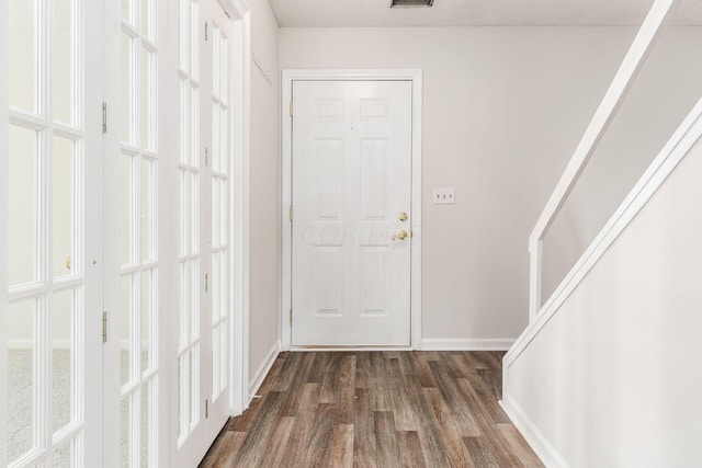 doorway to outside with visible vents, baseboards, and dark wood-style flooring