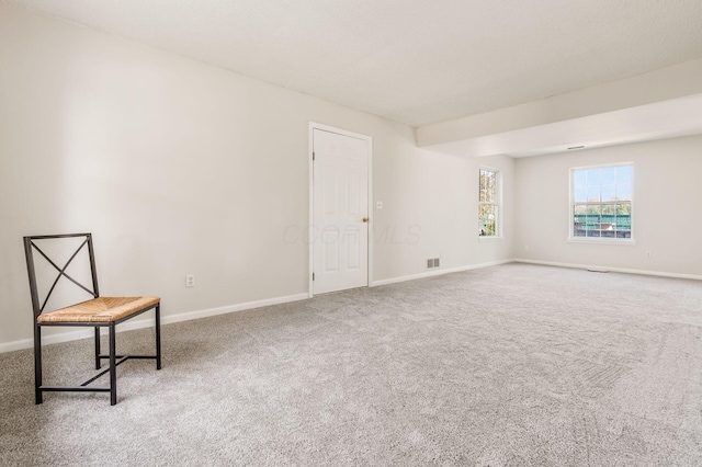 carpeted empty room with visible vents and baseboards