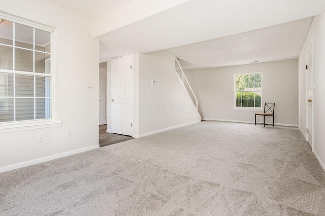 unfurnished room featuring carpet and baseboards