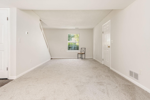 unfurnished room featuring visible vents, baseboards, and carpet flooring