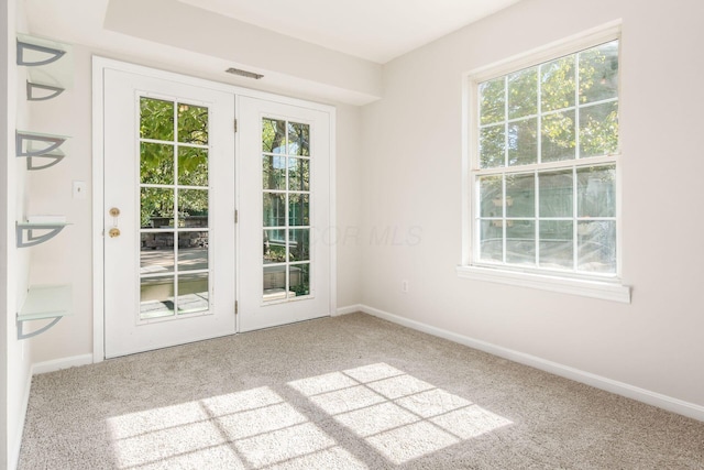 doorway to outside featuring visible vents, baseboards, and carpet flooring