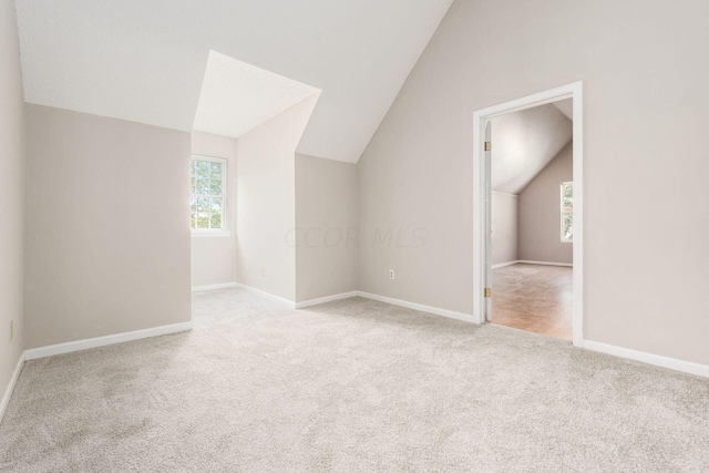 bonus room with vaulted ceiling, carpet floors, and baseboards