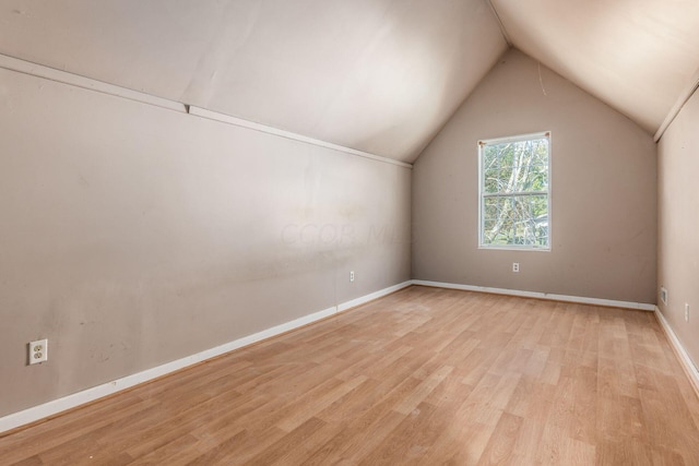 additional living space with vaulted ceiling, light wood-style flooring, and baseboards