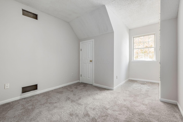 bonus room with lofted ceiling, a textured ceiling, baseboards, and carpet flooring