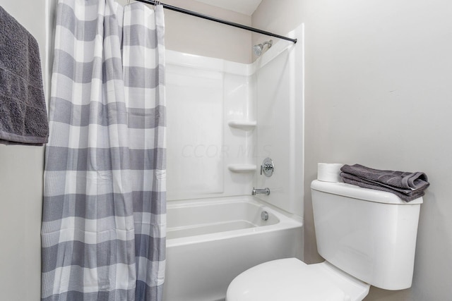 bathroom featuring shower / tub combo and toilet