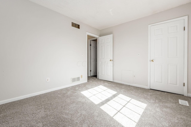 unfurnished bedroom featuring carpet flooring, visible vents, and baseboards