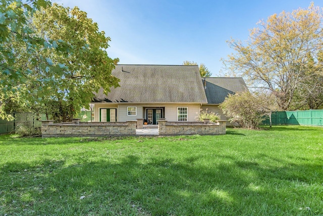 rear view of house featuring fence, a yard, french doors, roof with shingles, and a patio area