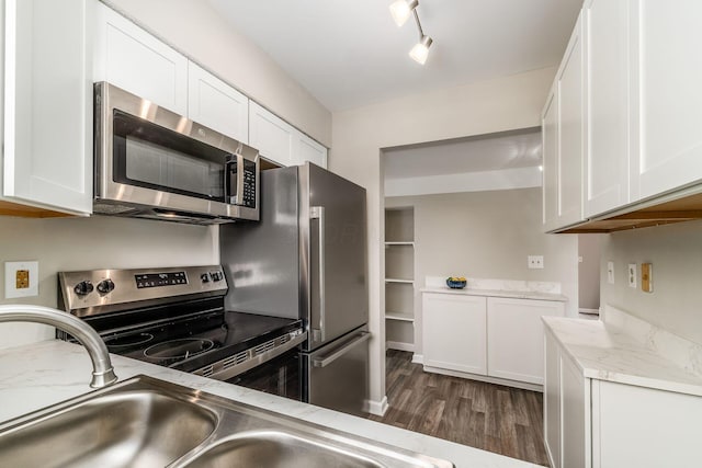 kitchen featuring appliances with stainless steel finishes, dark wood-style flooring, white cabinets, and light stone countertops