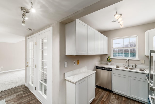 kitchen featuring a sink, visible vents, dark wood-type flooring, and stainless steel dishwasher