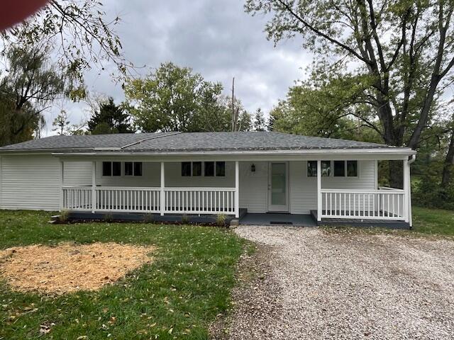 ranch-style house with a front yard and covered porch