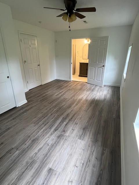 641/2 N Beaver St, Carroll, OH 43112 - unfurnished bedroom featuring wood finished floors, ensuite bathroom, ceiling fan, and multiple windows