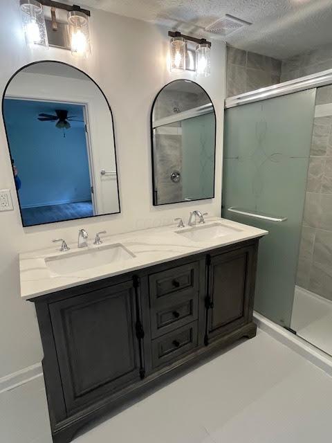 641/2 N Beaver St, Carroll, OH 43112 - bathroom with double vanity, a shower stall, and a textured ceiling