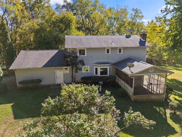 rear view of property with a lawn and a sunroom