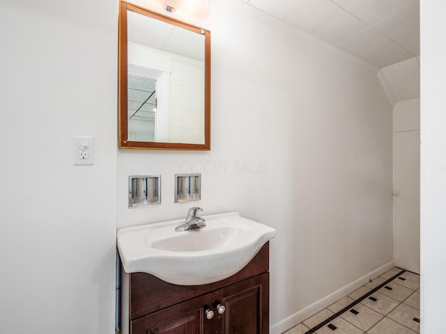 bathroom with tile patterned floors, crown molding, and vanity