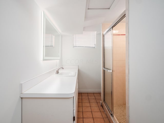 bathroom with tile patterned floors, vanity, and walk in shower