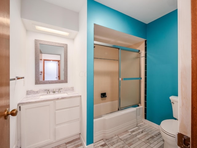 full bathroom with tile patterned flooring, vanity, bath / shower combo with glass door, and toilet