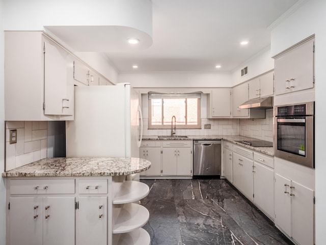 kitchen featuring white cabinetry, sink, appliances with stainless steel finishes, and tasteful backsplash