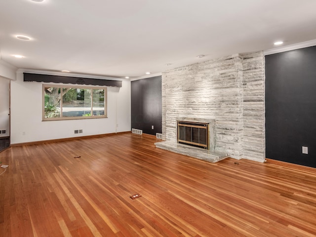 unfurnished living room with a fireplace, ornamental molding, and hardwood / wood-style flooring