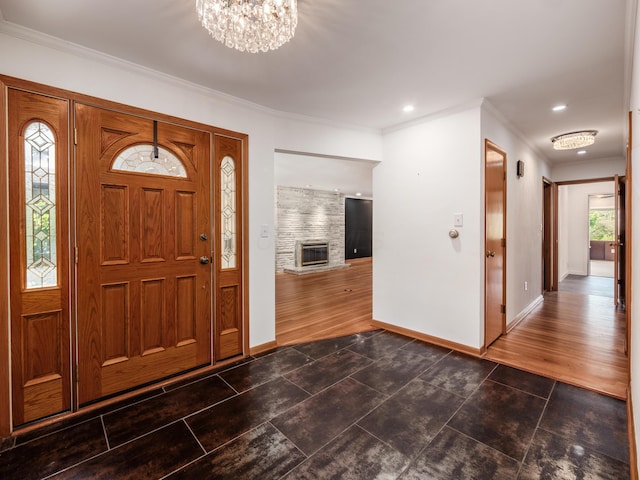 foyer featuring dark hardwood / wood-style flooring, ornamental molding, and a chandelier