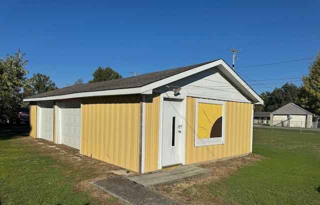 view of outdoor structure with a lawn and a garage