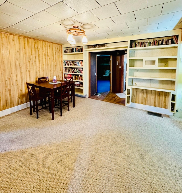 unfurnished dining area with wood walls and carpet