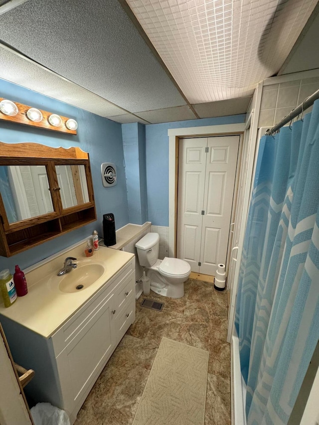 bathroom featuring curtained shower, vanity, and toilet