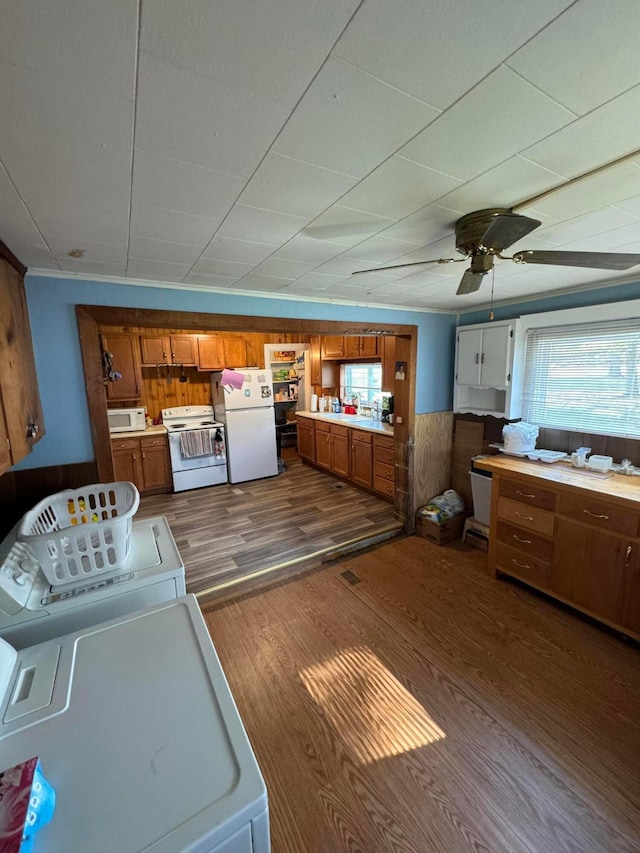 washroom featuring washing machine and dryer, wooden walls, dark hardwood / wood-style flooring, and ceiling fan