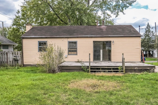 back of property featuring a wooden deck and a yard